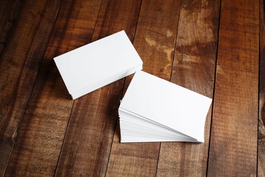 Photo of blank business cards on vintage wooden table background. Mock up for design portfolios. Responsive design template. Top view.