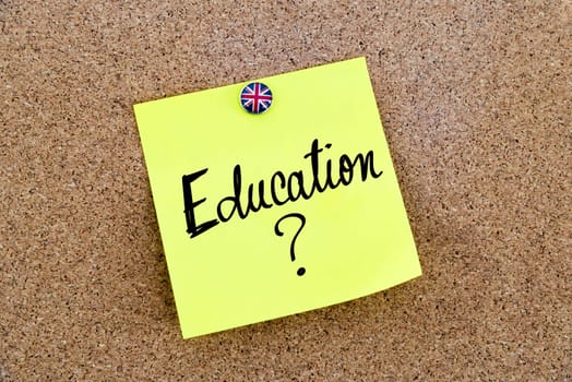 Yellow paper note pinned on cork board with Great Britain flag thumbtack, written text EDUCATION ?, United Kingdom exit from European Union concept