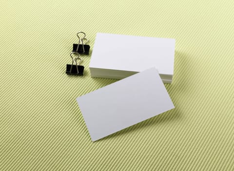 Stack of blank business cards on a green background. Template for branding identity.
