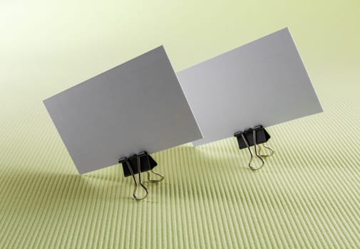 Photo of two blank business cards on a green background.