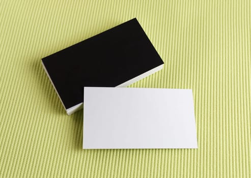 Blank black and white business cards on a green background. Template for branding identity.