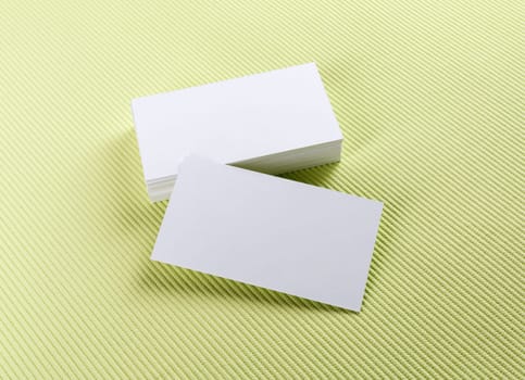 A stack of business cards on a green background. Template for branding identity.