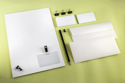 Blank corporate identity set on green background. Top view.