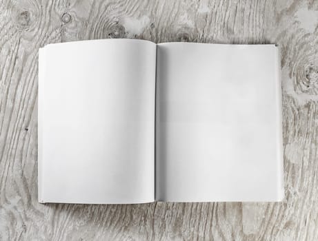 Blank opened book on wooden background. Top view.