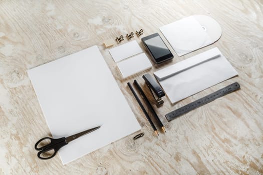 Blank stationery and corporate identity set on light wooden background. Template for design presentations and portfolios. Top view.
