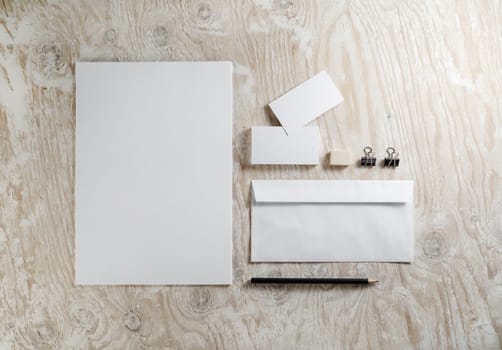 Blank stationery set on light wooden background. Template for ID.