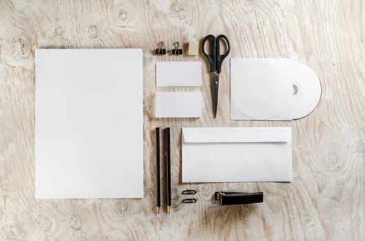 Stationery set on light wooden background. Blank template for design presentations and portfolios.