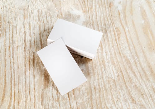Blank business cards on light wooden background. Template for branding identity. Top view.