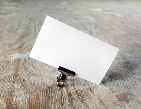 Photo of blank business card with soft shadow on light wooden background. Mock-up for branding identity. Template for graphic designers portfolios.