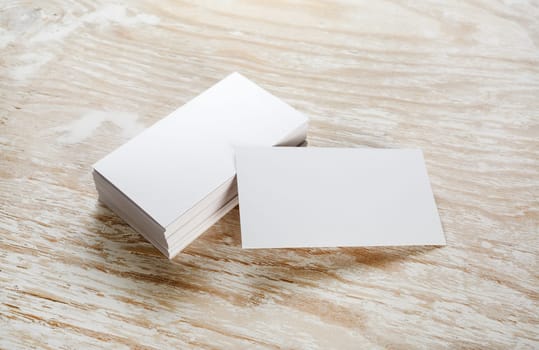 Photo of blank business cards on a wooden background. Template for ID.