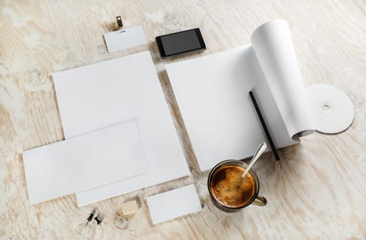 Corporate identity template on light wooden background. Blank stationery set. For design presentations and portfolios. Top view.