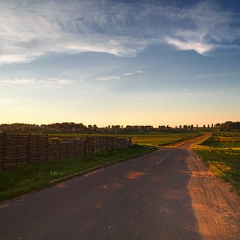 Landscape with the old asphalt road in the countryside. Evening. Square frame.