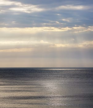Beautiful seascape with dramatic sky and the sea. Sunlight breaks through the clouds.