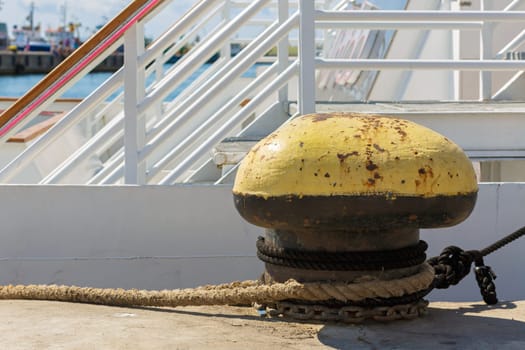 Old rusty mooring bollard at the pier. A large fragment of the dock port.