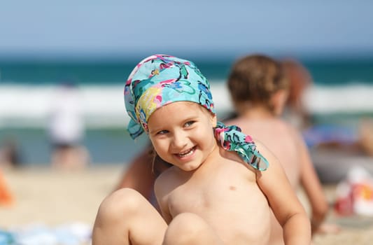 Laughing little girl on the beach. Focus on model. Shallow depth of field.