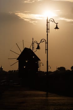 Silhouette of windmills and streetlights at daybreak. Shallow depth of field.