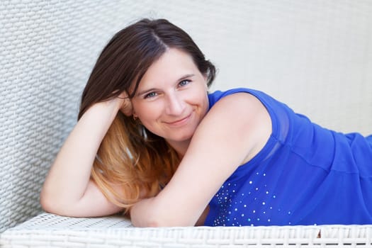 Girl in blue shirt posing, looking at the camera and smiling. Closeup portrait. Shallow depth of field.