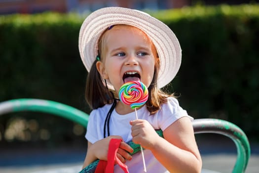 Little girl eating big candy. Shallow depth of field.