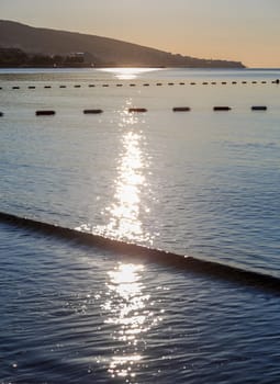 Reflection of the sun in the morning on the sea. Vertical shot.