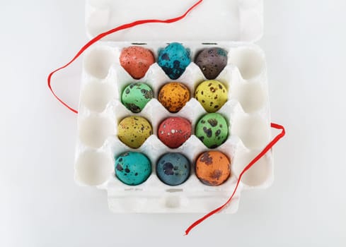 Easter eggs. Colored painted quail eggs in a cardboard box.