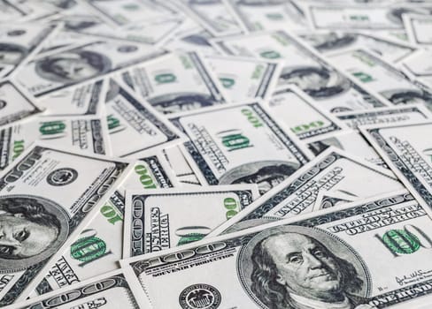 Pile of one hundred dollar bills. Money as background. Shallow depth of field. Selective focus.