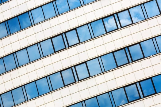 MINSK, BELARUS - MAY 03, 2016: Close-up of Minsk-Arena - a sports and entertainment complex in the city of Minsk, Belarus. Close-up of modern architecture. Reflection of blue sky with clouds in the windows.