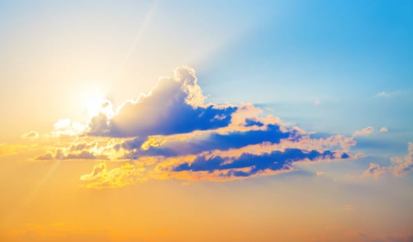 Beautiful bright sunset. Colorful sky with cumulus clouds and bright sun.