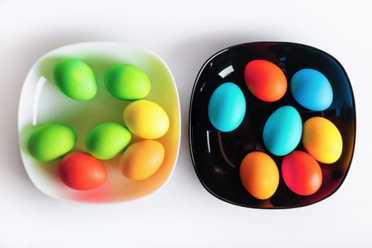Two dishes with multi-colored bright Easter eggs. Top view.