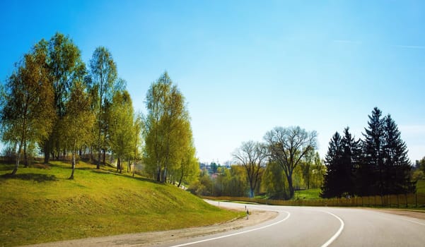Asphalt road in the countryside. Sunny summer day. Turn of asphalt road.
