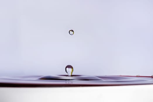 A drop of water falling into the water. Shallow depth of field. Selective focus.