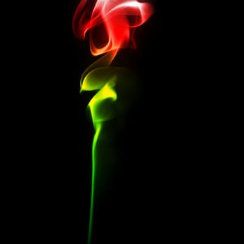 Abstract bright colored smoke on a dark background. Smoke rose from.