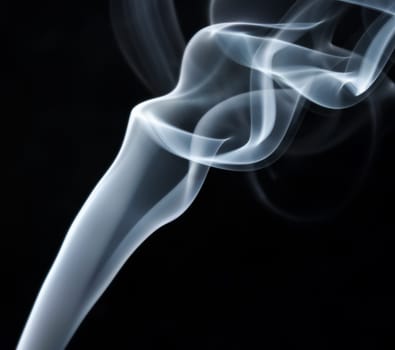 Abstract smoke swirls over black background. Studio shot.