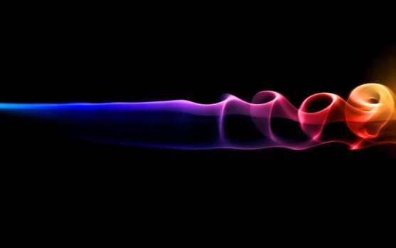 Abstract colorful smoke on black on a dark background.
