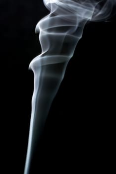 Photo of abstract smoke swirls on black background. Vertical shot.
