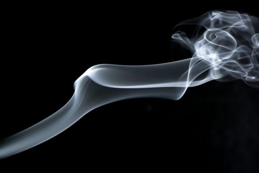 Photo of abstract smoke swirls on black background. Studio shot.