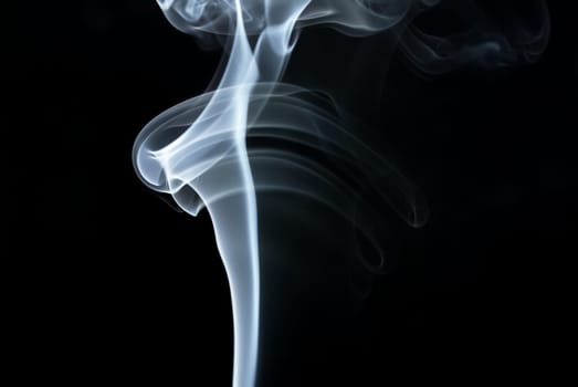 Photo of abstract smoke swirls over black background.