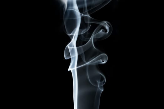 Photo of abstract light smoke swirls on black background. Studio shot.