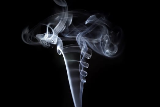 Photo of abstract smoke swirls on black background. Studio shot.