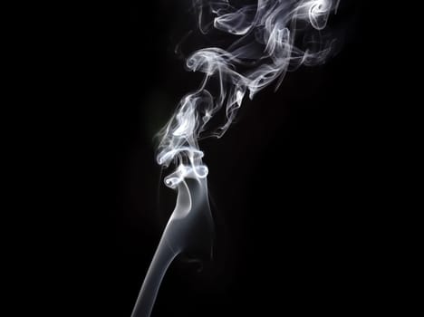 Photo of abstract smoke swirls on dark background. Studio shot.