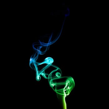 Abstract bright colored smoke on a dark background.