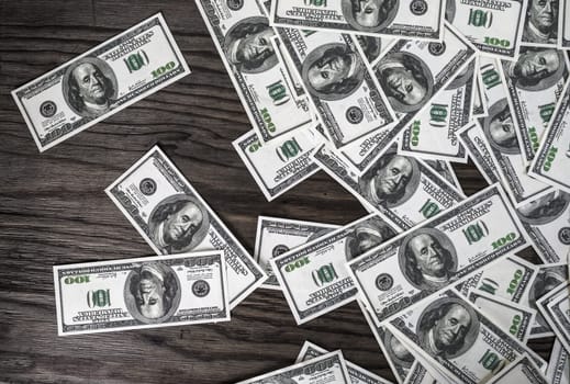 Many one hundred dollar bills on dark wooden background. Fake money. Concept of business theme.