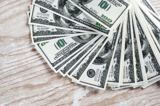 Many one hundred dollar bills on light wooden background. Pile of money.