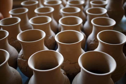 Many rustic handmade terracotta clay pots. Shallow depth of field. Selective focus.