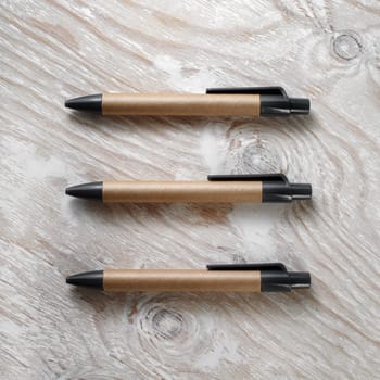 Cardboard pens on a light wooden background. Mockup for branding identity. Template for design presentations and portfolios. Top view.