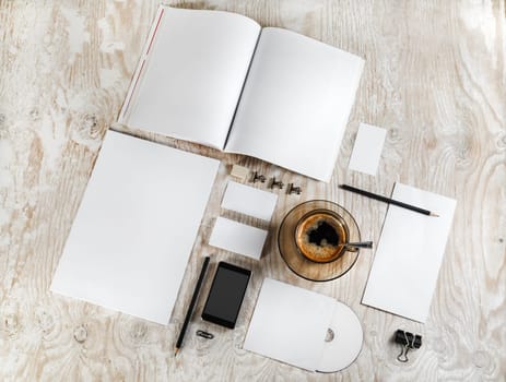 Photo of blank stationery. Corporate identity template on light wooden background. For design presentations and portfolios. Top view.