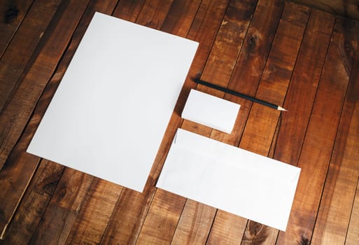Blank stationery set on vintage wooden background. Blank ID template. Mock-up for branding identity for designers. Letterhead, business cards, envelope and pencil. Top view.