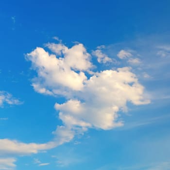Blue sky with white cumulus clouds on a bright sunny summer day