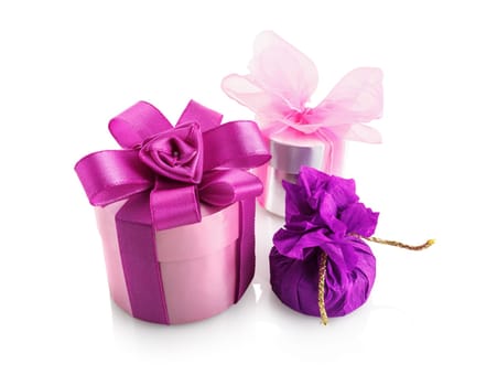 Three bright colorful gift boxes on a white background with reflection. Isolated with clipping path.