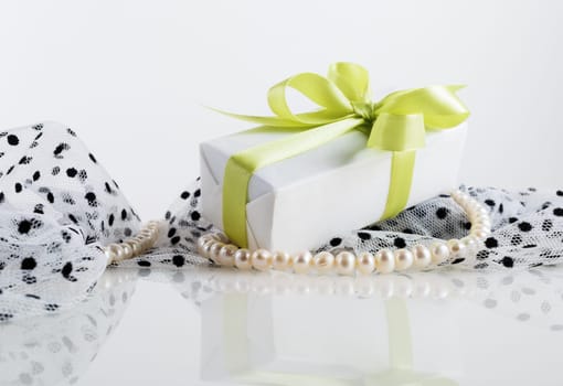 Still life with gift box, pearl beads and fabrics.