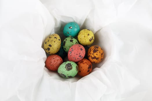 Colored quail eggs on a white background wrapping paper. Top view.
